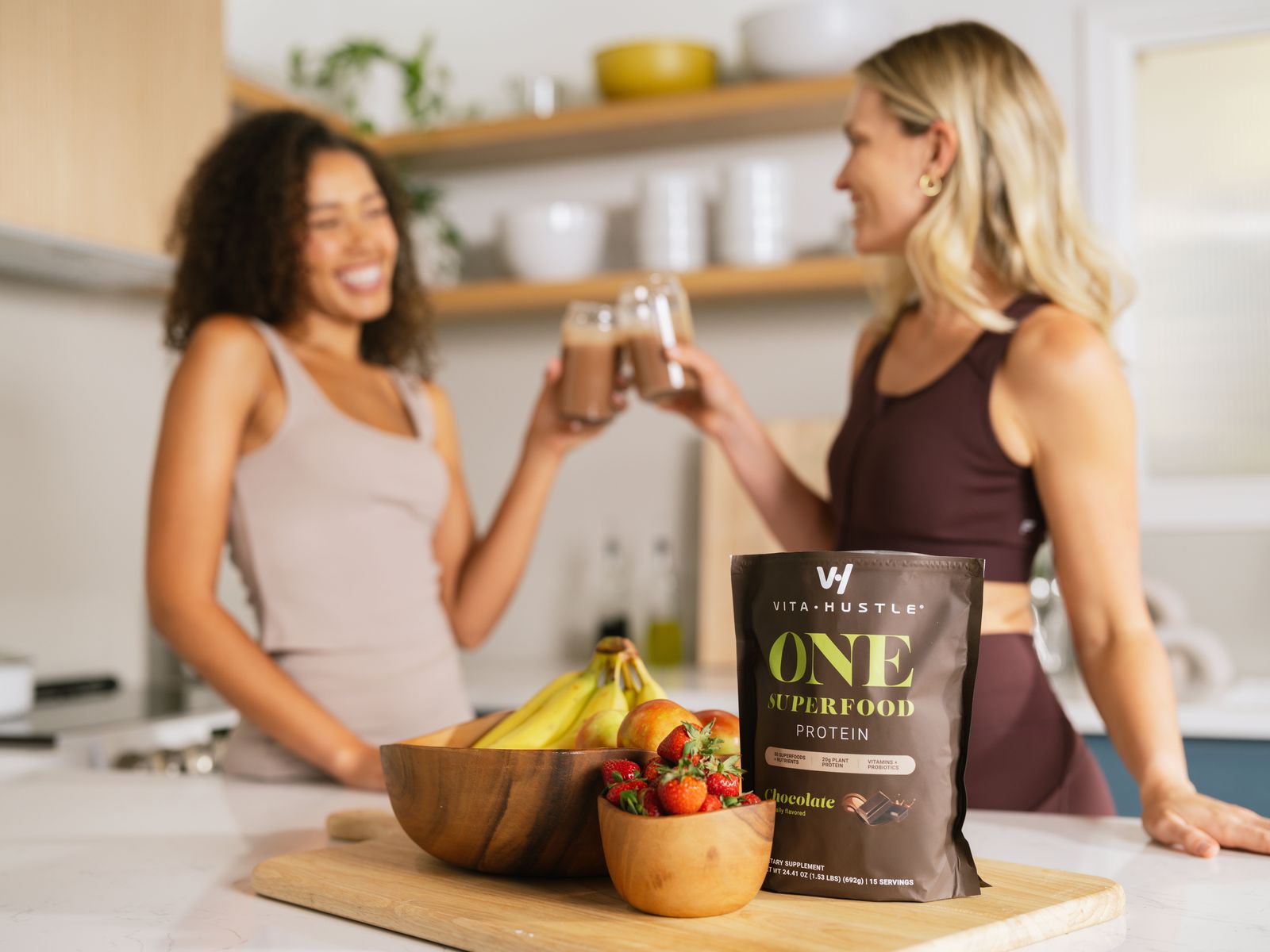 Two friends toasting VitaHustle chocolate shakes